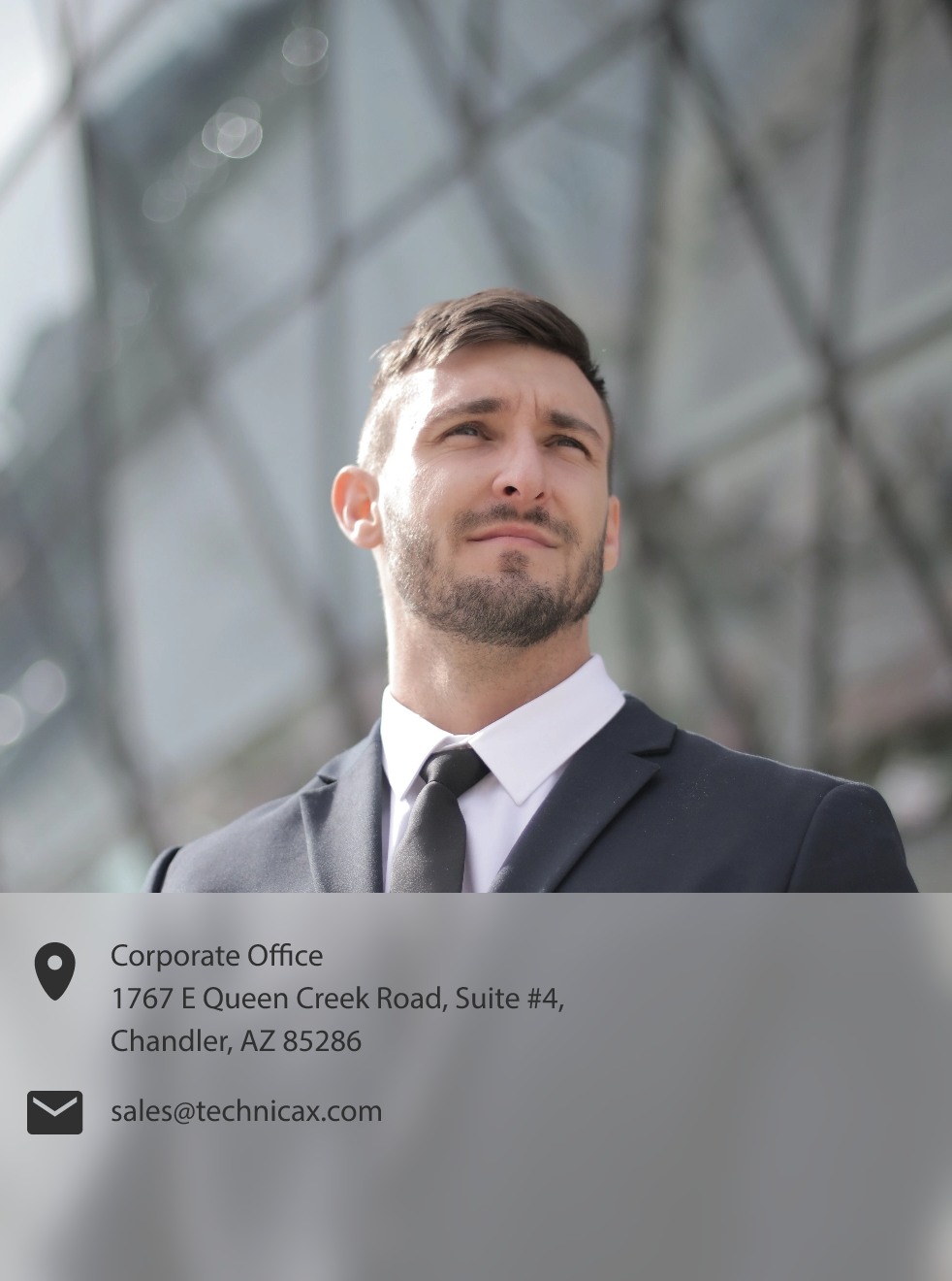 A professional man in a suit smiles confidently.